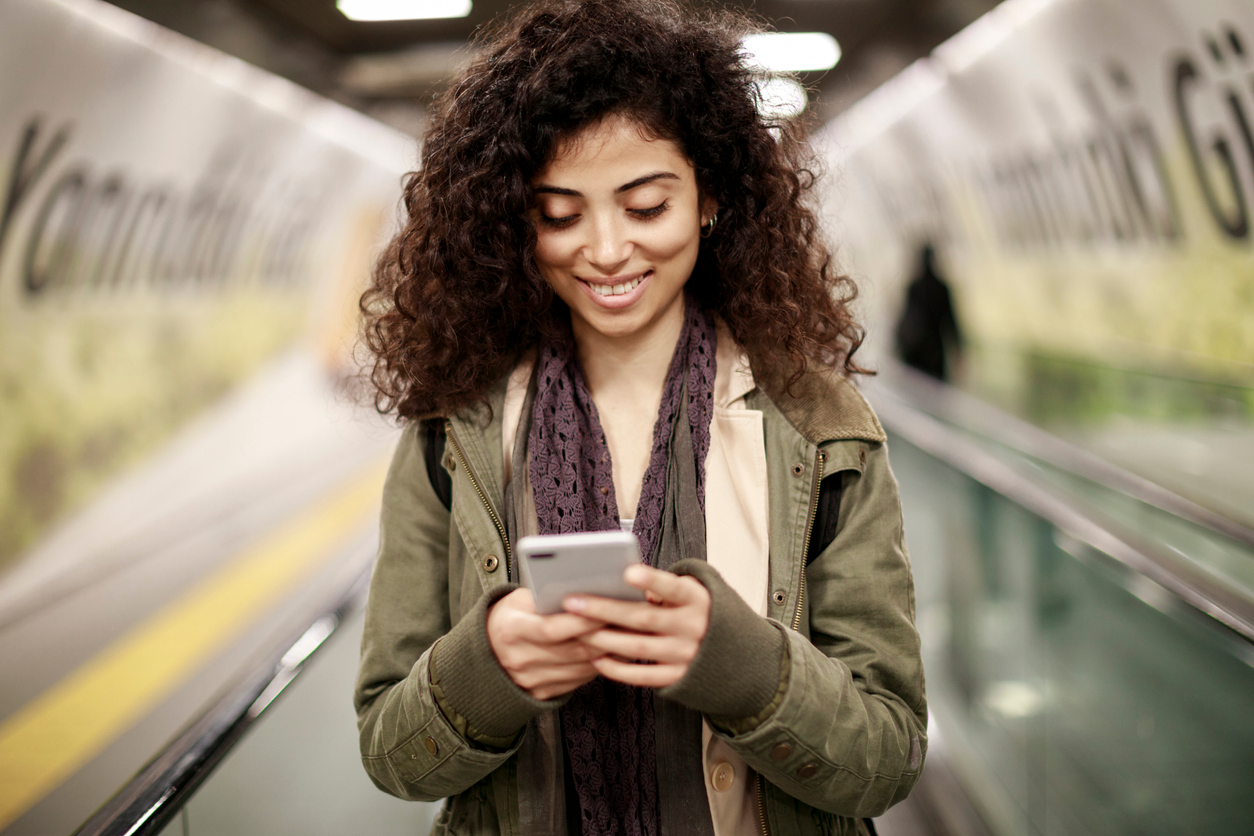 Young woman using mobile phone in the subway station