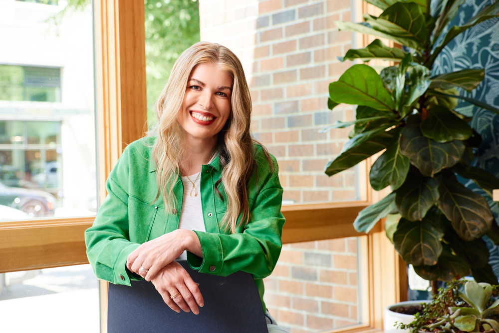 Meghan Kelly, Formada's Co-founder and CEO, wearing a green jacket, smiles at the camera