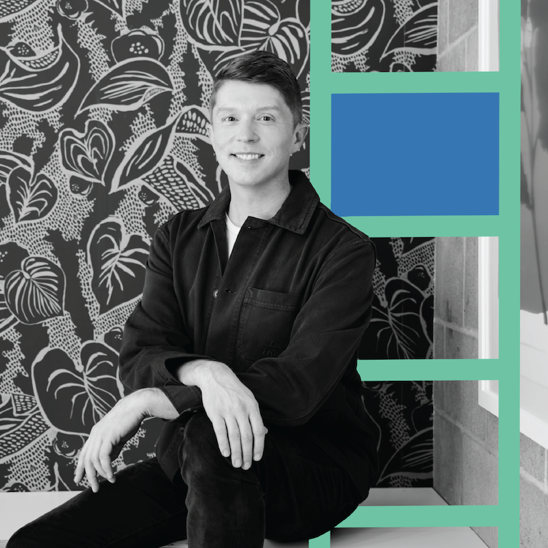 Formada VP of Brand Strategy, Nathan Miller, sits on a shelf with his arms crossed over his knee. He is shot and black and white and flanked to the right by a teal and blue rectangular graphic resembling a ladder.