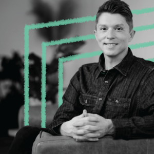 An image of Formada's VP of Brand Strategy, Nathan Miller. He is shot in black and white, seated, pictured from the waist up. Behind him, are three green teal squares.