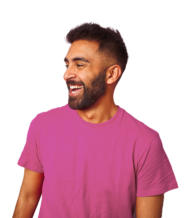malibu A young man with a dark brown beard, wears a magenta t-shirt while smiling brightly and looking to the left.