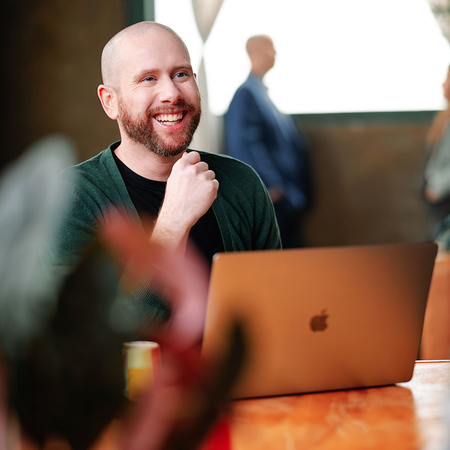 David Kerr, VP of Design at Formada, smiles while working on his laptop